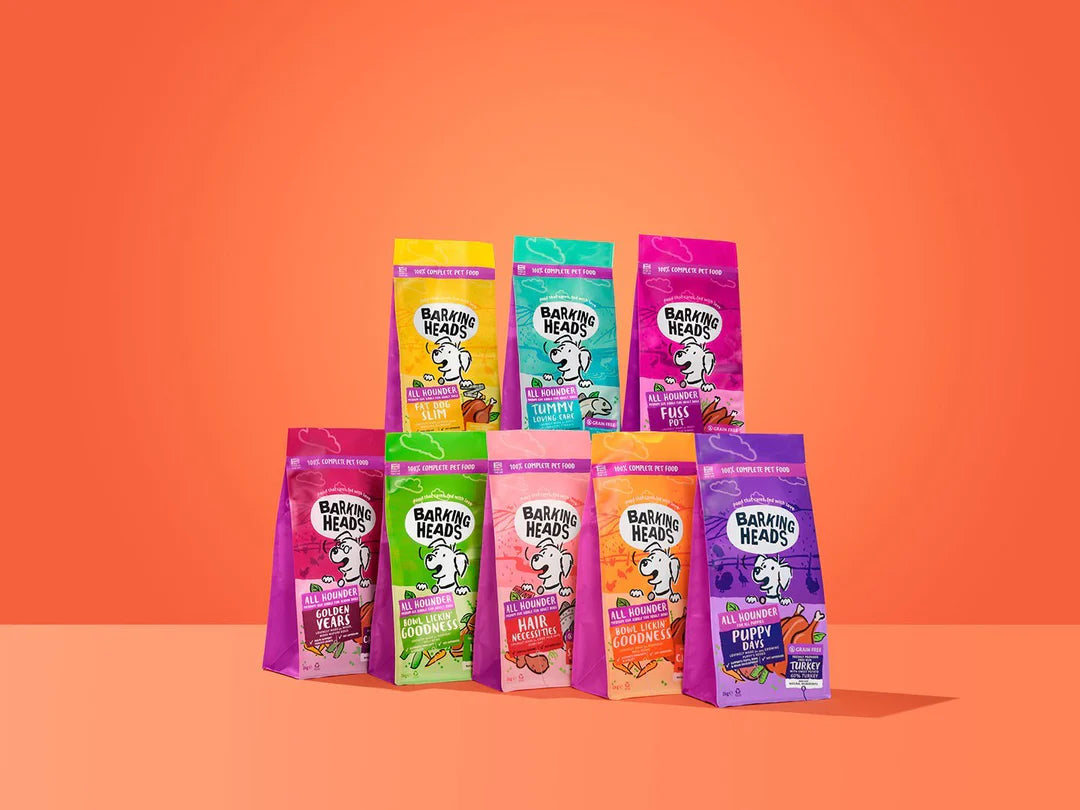 Assorted bags of Barking Heads dog food on an orange background